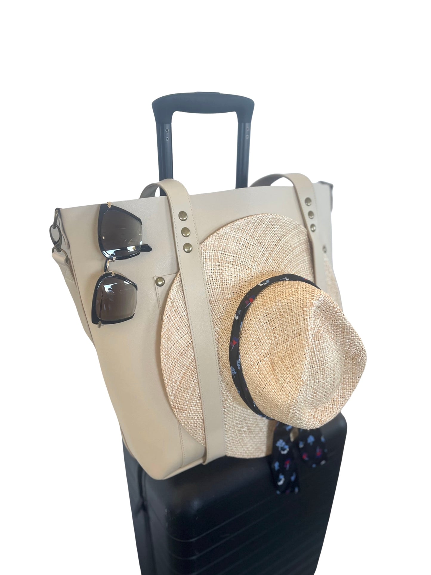 the everywhere tote ivory with hat on luggage side