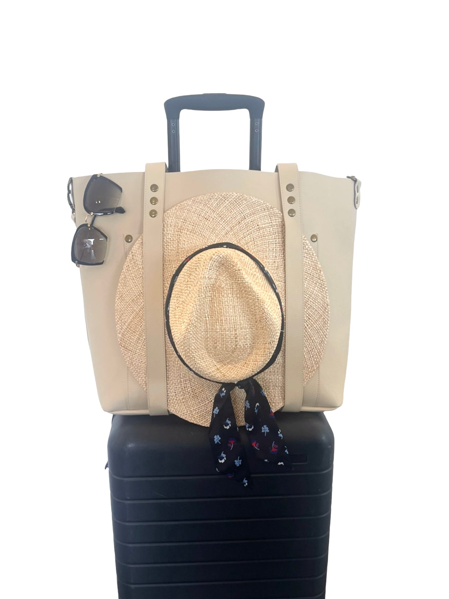 the everywhere tote ivory with hat on luggage